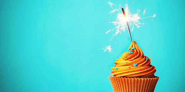 Orange cupcake with sparkler and copy space to side